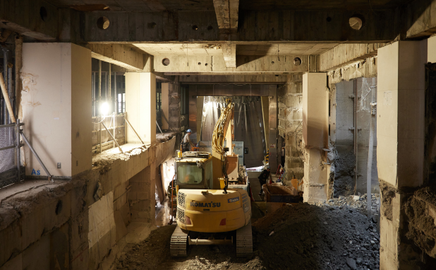 １階に落とされたコンクリートガラを運搬車両に積み込む油圧ショベル。ここでもコマツの建機が働いています。